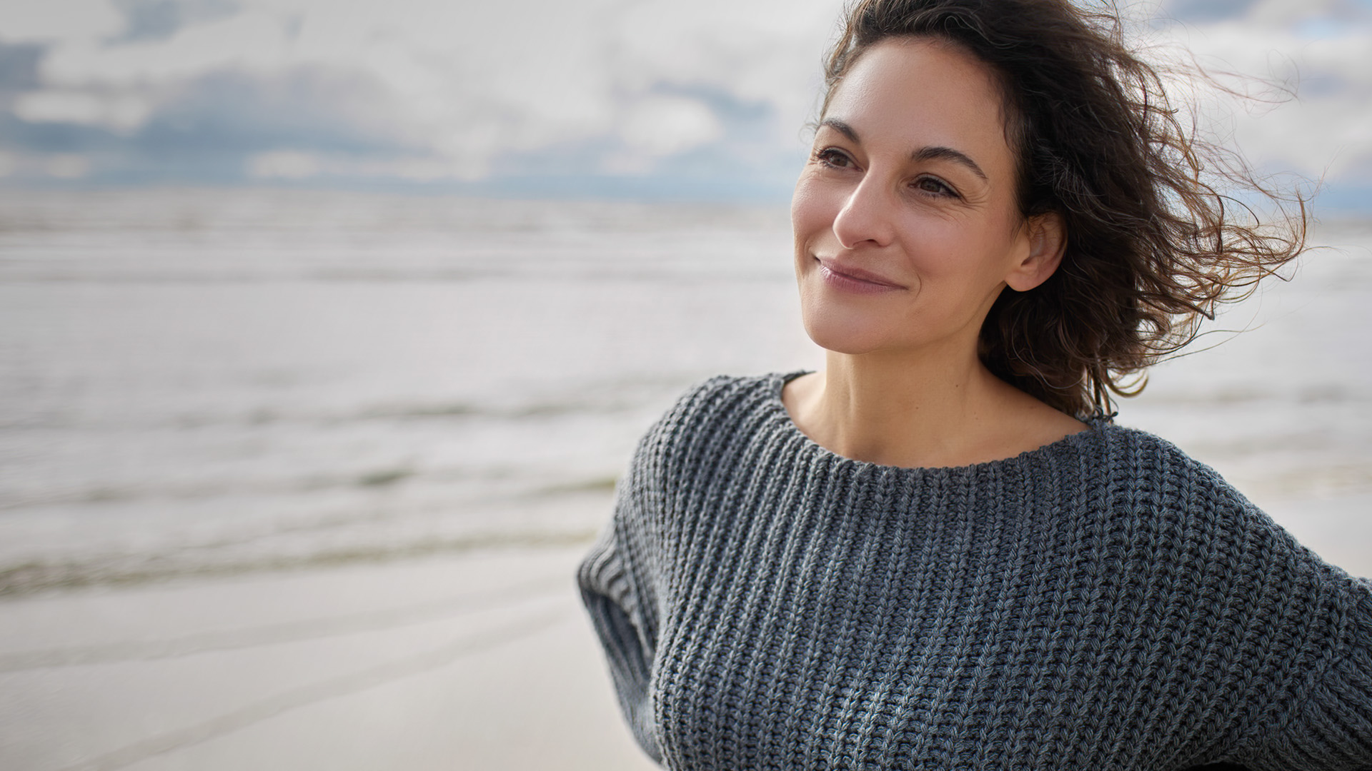 Frau in Wind am Strand