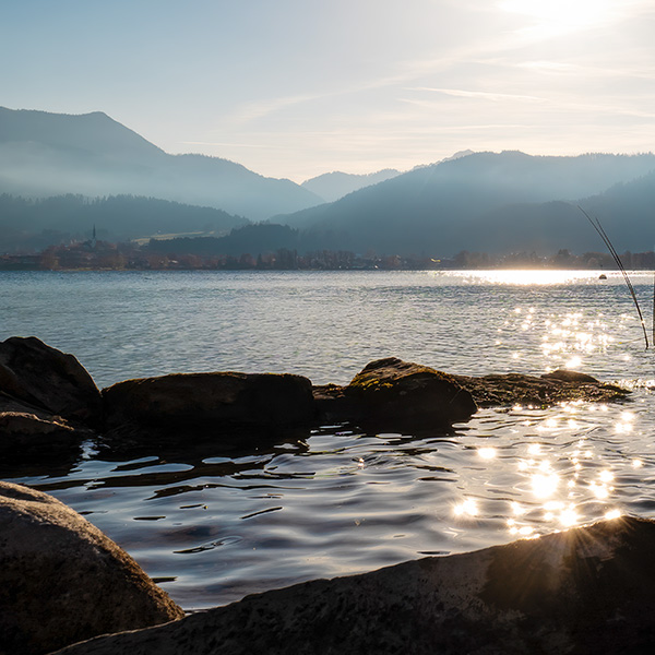 Blick über den Tegernsee bei Sonnenaufgang mit Bergpanorama 